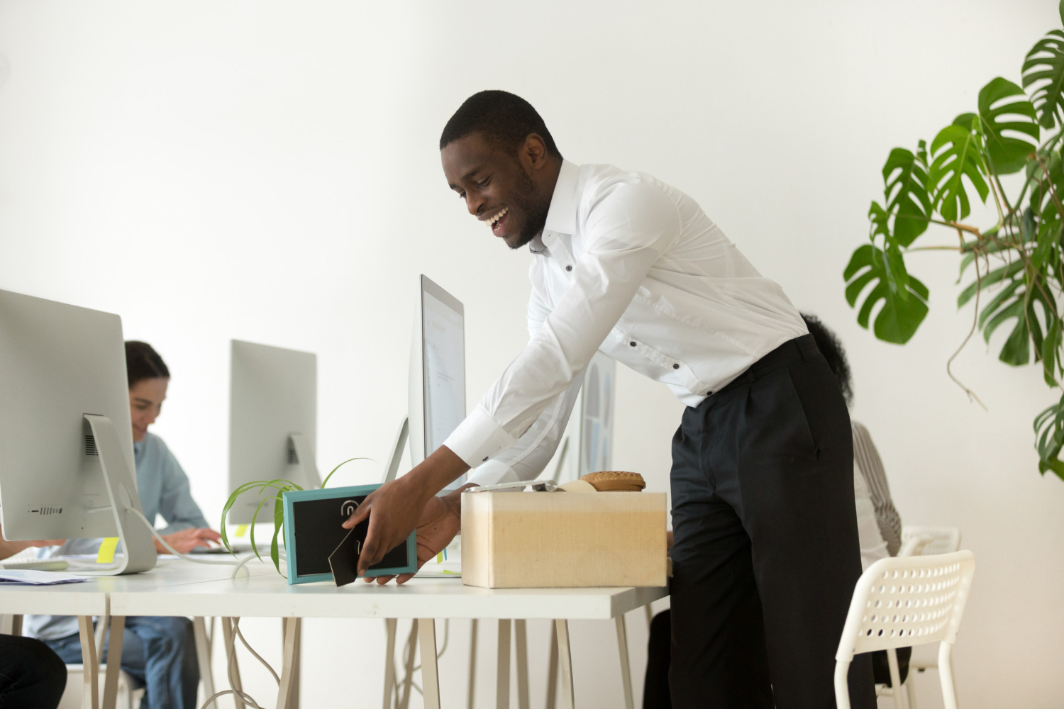 happy-african-new-employee-unpacking-belongings-first-working-day